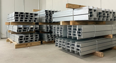 Galvanised steel retaining wall posts and C-channels stacked in warehouse ready for retaining wall construction in Melbourne